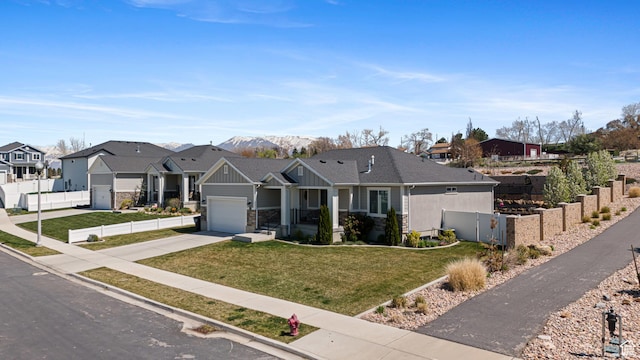 view of front of home with board and batten siding, a garage, fence, driveway, and a residential view