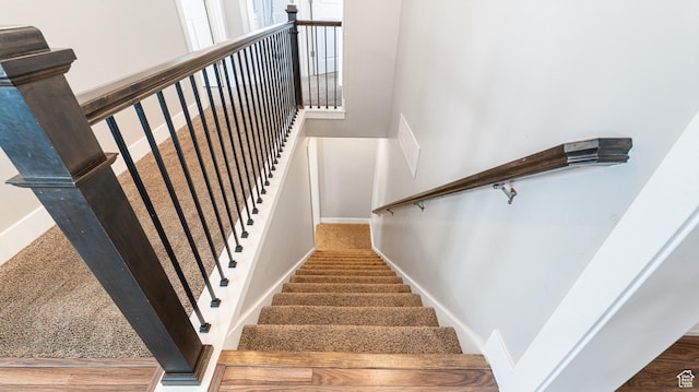 stairway featuring baseboards and a towering ceiling