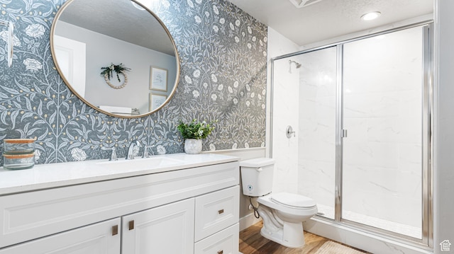 bathroom with toilet, a stall shower, and wallpapered walls