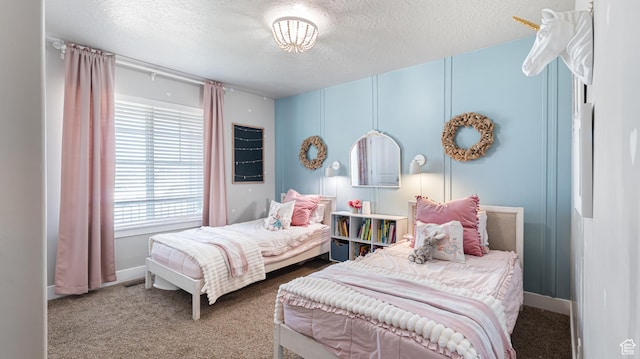 carpeted bedroom featuring baseboards and a textured ceiling