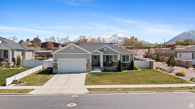 craftsman-style home with fence, driveway, board and batten siding, and a mountain view