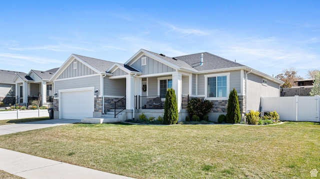 craftsman-style home featuring board and batten siding, fence, stone siding, and concrete driveway