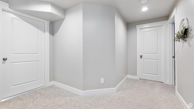 hallway with baseboards, recessed lighting, and carpet