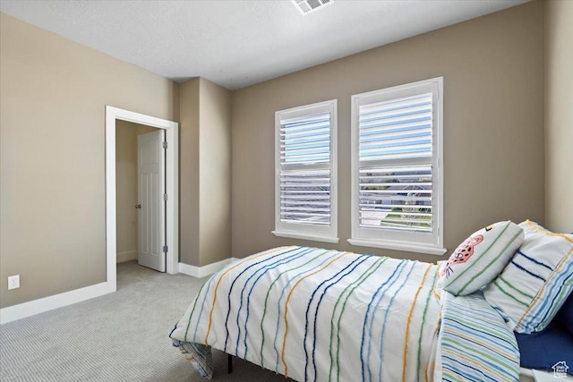 carpeted bedroom featuring visible vents, multiple windows, and baseboards