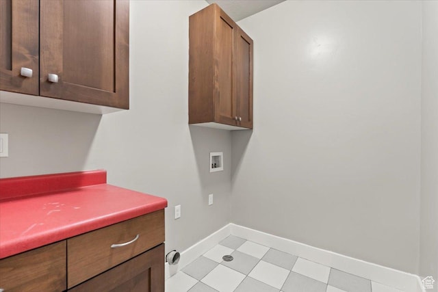 laundry room featuring baseboards, washer hookup, and cabinet space