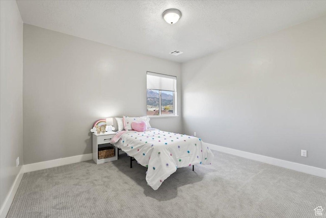 bedroom with visible vents, baseboards, carpet, and a textured ceiling