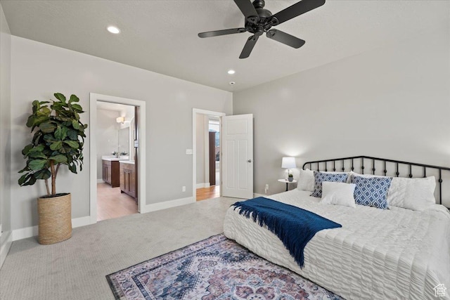 bedroom with a sink, baseboards, recessed lighting, and light carpet