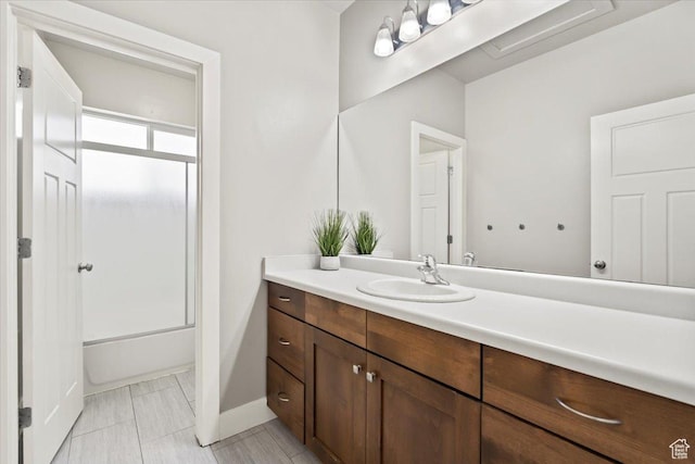 full bath featuring  shower combination, vanity, and baseboards