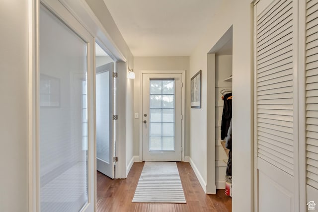 doorway to outside featuring wood finished floors and baseboards