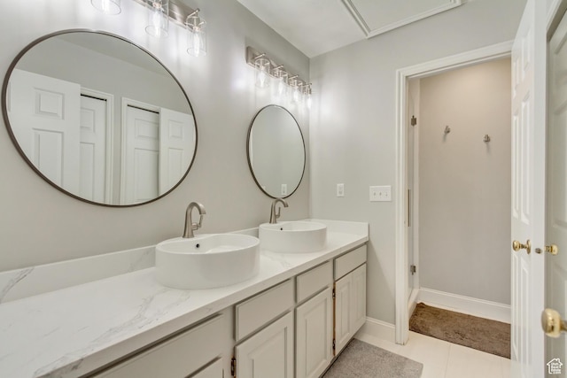 bathroom featuring tile patterned flooring, double vanity, and a sink