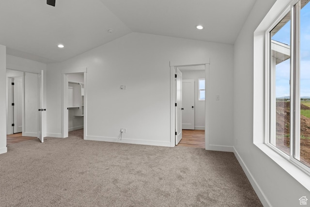232 N 300 W, Preston, ID 83263 - unfurnished bedroom featuring multiple windows, light colored carpet, lofted ceiling, baseboards, and a walk in closet