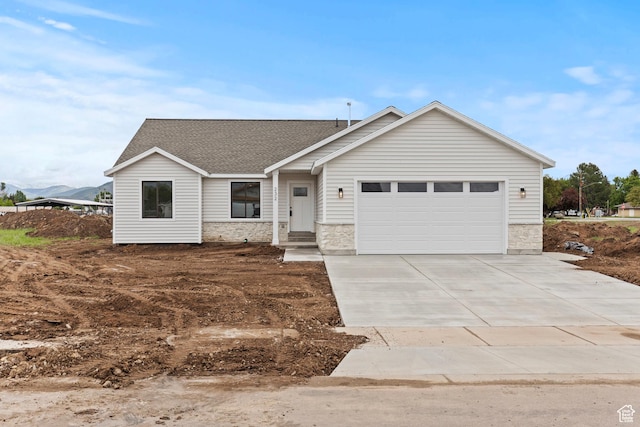 232 N 300 W, Preston, ID 83263 - view of front of house featuring stone siding, driveway, a garage, and roof with shingles