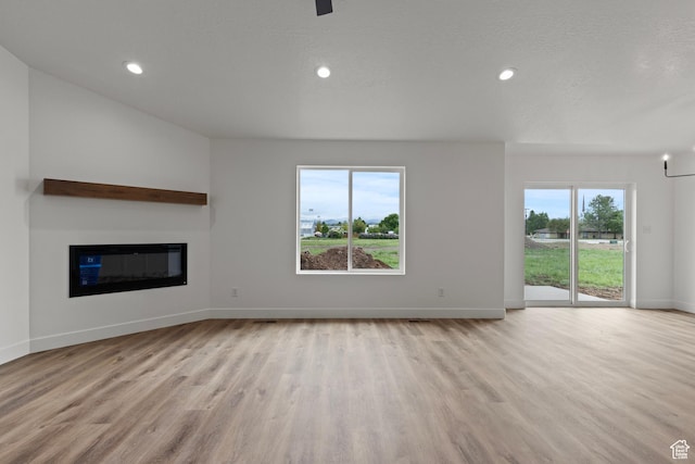 232 N 300 W, Preston, ID 83263 - unfurnished living room with wood finished floors, baseboards, a glass covered fireplace, and recessed lighting