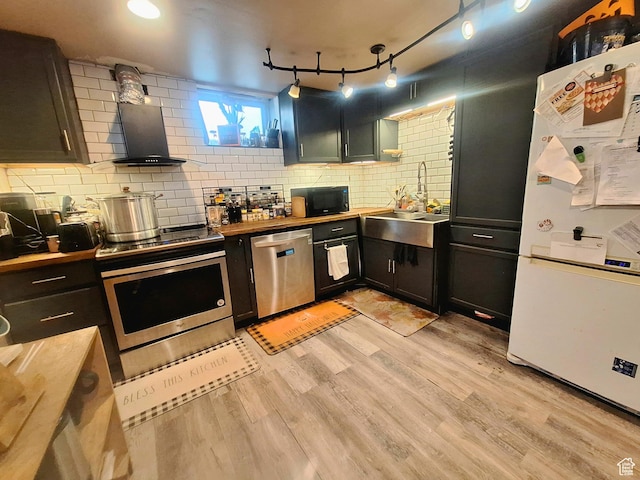 3150 N Iowa Ave E, Ogden, UT 84403 - kitchen featuring appliances with stainless steel finishes, wooden counters, wall chimney range hood, and light wood-style floors