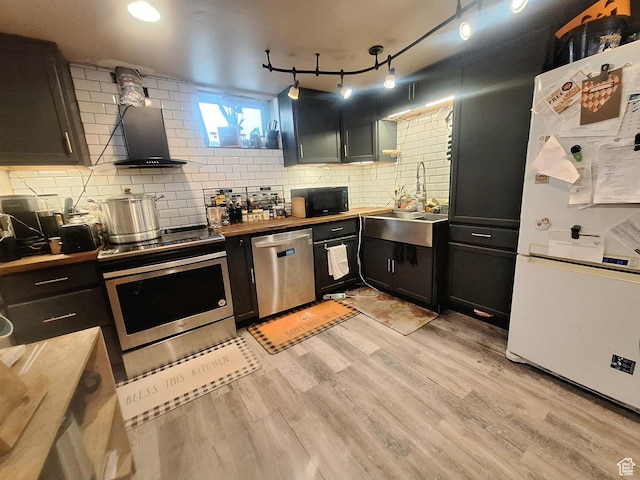 3150 N Iowa Ave W, Ogden, UT 84403 - kitchen featuring dark cabinets, light wood-style flooring, a sink, stainless steel appliances, and backsplash