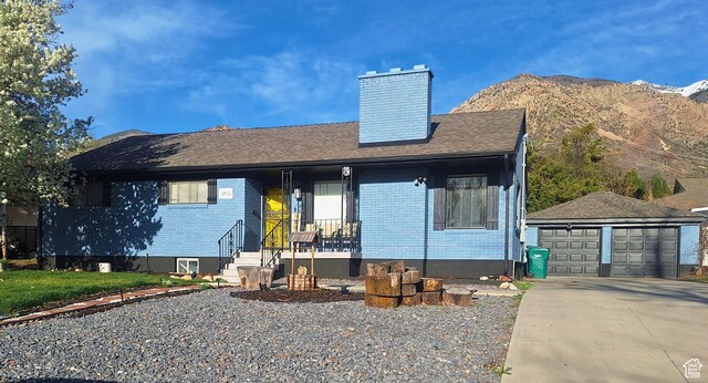 3150 N Iowa Ave E, Ogden, UT 84403 - ranch-style house featuring covered porch, an outbuilding, a chimney, a detached garage, and a mountain view
