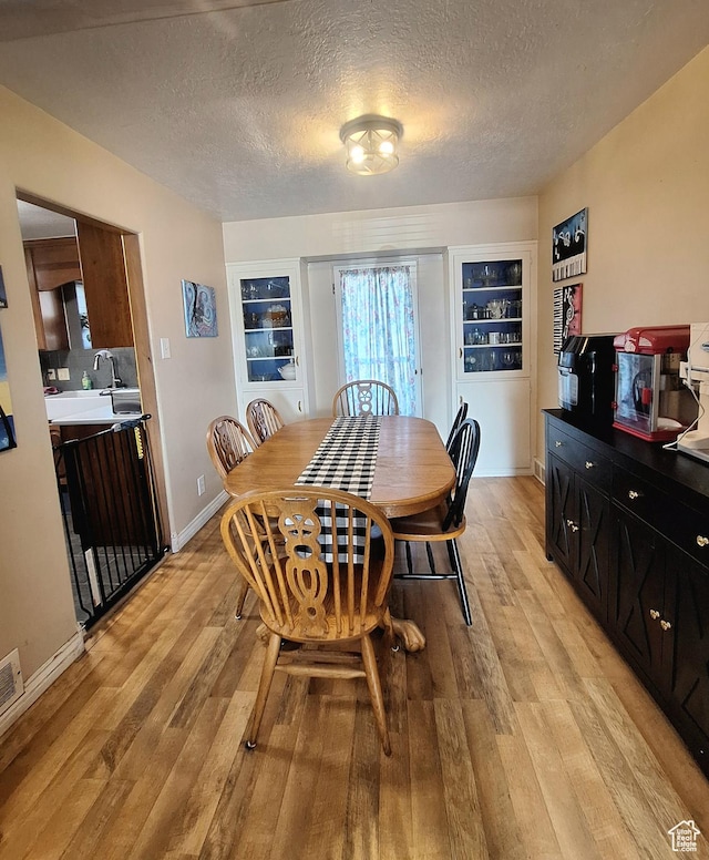 3150 N Iowa Ave W, Ogden, UT 84403 - dining room featuring light wood-type flooring, baseboards, and a textured ceiling