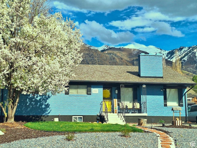3150 N Iowa Ave E, Ogden, UT 84403 - view of front of property with a mountain view, brick siding, a porch, and roof with shingles