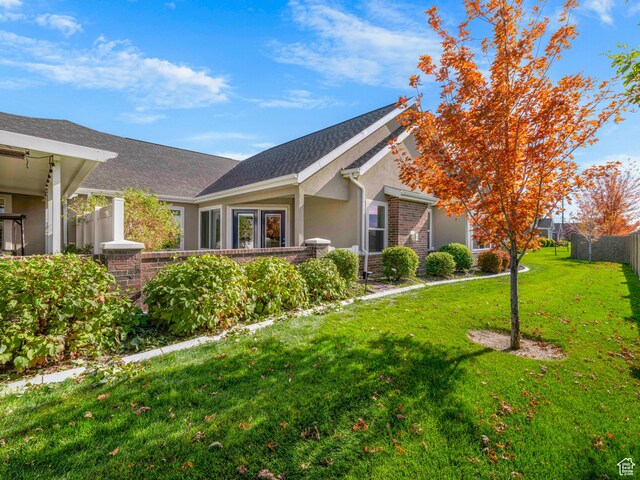 1262 S 50 E Unit 3, Lehi, UT 84043 - exterior space with a shingled roof, stucco siding, fence, and a lawn