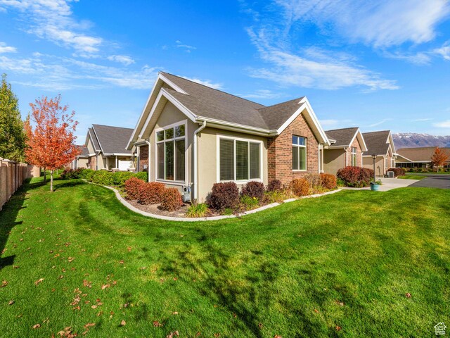 1262 S 50 E Unit 3, Lehi, UT 84043 - view of property exterior featuring fence, a shingled roof, a lawn, and stucco siding
