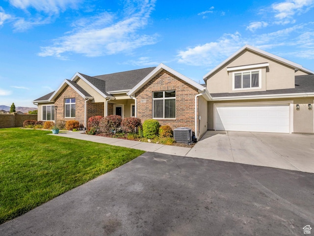 view of front facade with a garage, cooling unit, stucco siding, a front yard, and concrete driveway