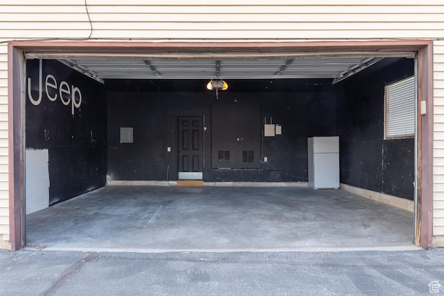 garage with freestanding refrigerator and a garage door opener