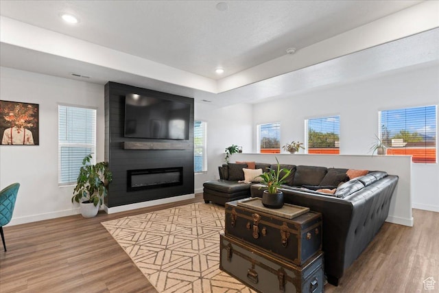 living room with recessed lighting, a fireplace, baseboards, and wood finished floors