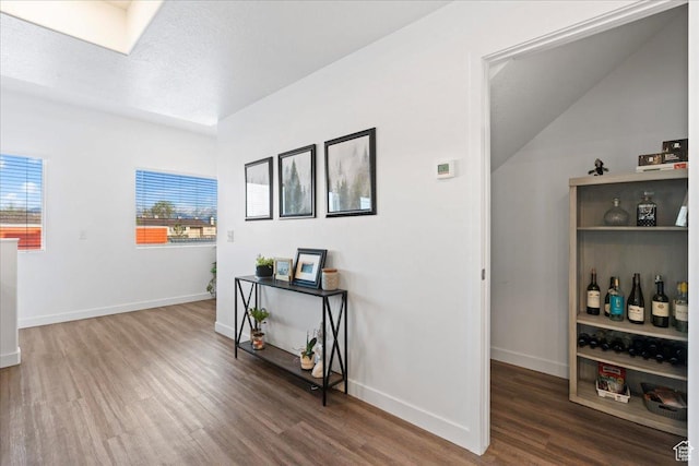 hall featuring wood finished floors and baseboards