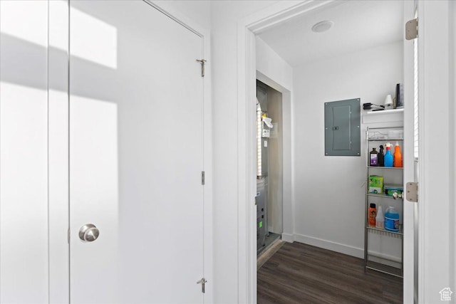 hall featuring dark wood-style flooring, baseboards, and electric panel