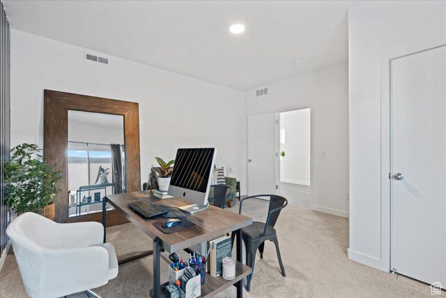 office area with visible vents, light colored carpet, and baseboards