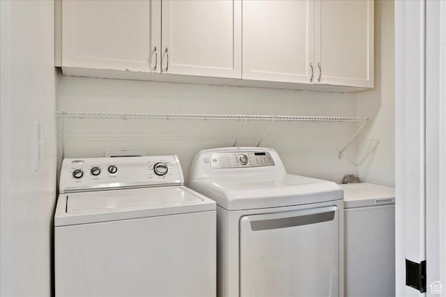 clothes washing area with cabinet space and washer and dryer