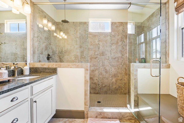 full bathroom with a shower stall, vanity, and a wealth of natural light