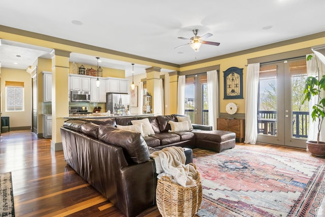 living room featuring french doors, dark wood-style flooring, and a ceiling fan