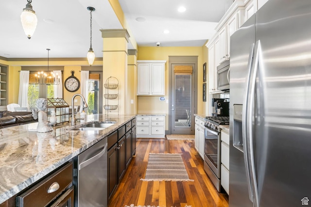 kitchen featuring dark brown cabinetry, white cabinetry, appliances with stainless steel finishes, a sink, and a notable chandelier