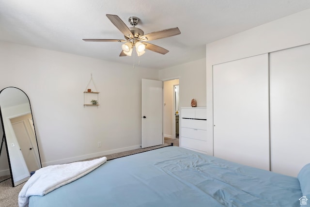 carpeted bedroom featuring a closet, ceiling fan, and baseboards