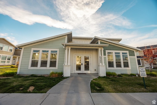 1221 W 2415 S, Nibley, UT 84321 - view of front facade featuring a front yard, french doors, and board and batten siding