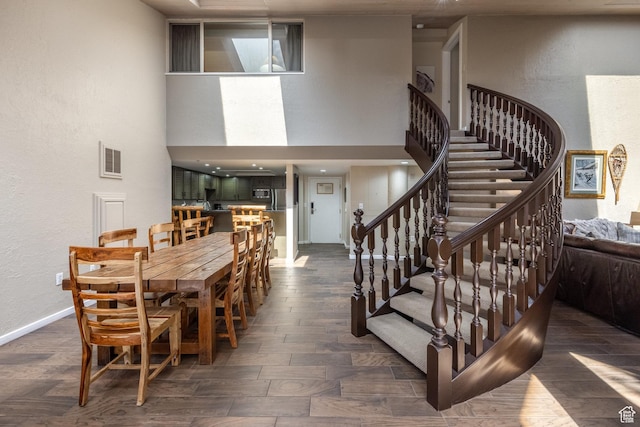 1485 Empire Ave Unit 506, Park City, UT 84060 - dining space featuring visible vents, baseboards, a high ceiling, a textured wall, and dark wood-style floors