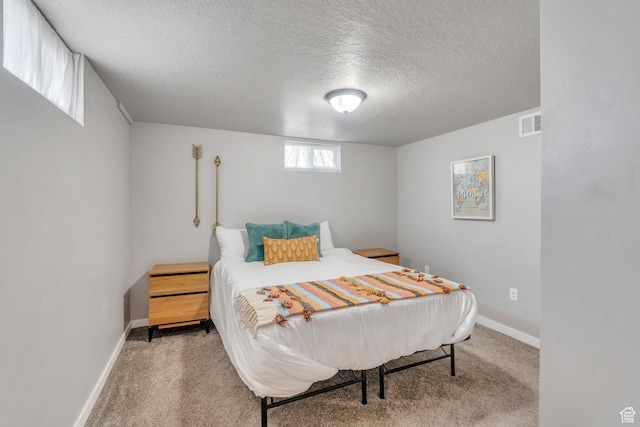 carpeted bedroom with visible vents, baseboards, and a textured ceiling