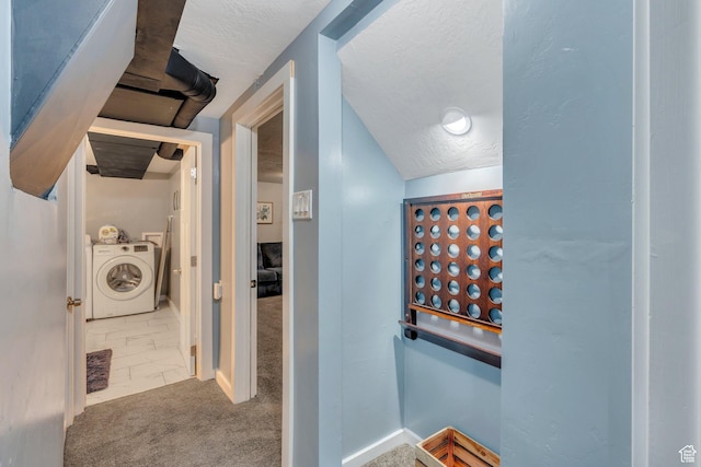 hallway with washer and clothes dryer, baseboards, carpet floors, and a textured ceiling