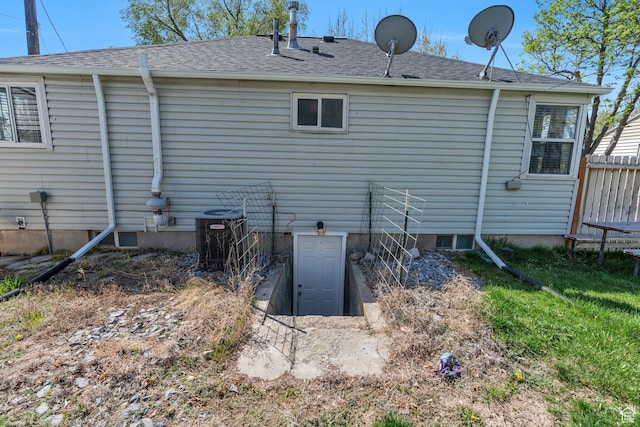 back of property featuring roof with shingles and central AC