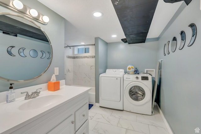 washroom featuring laundry area, marble finish floor, a sink, baseboards, and washing machine and dryer
