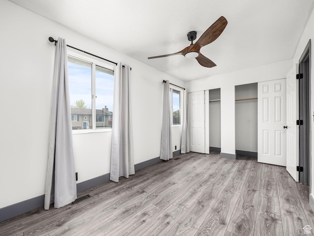 4866 W Diamondleaf Way S, West Jordan, UT 84081 - unfurnished bedroom featuring baseboards, multiple windows, light wood-type flooring, and multiple closets