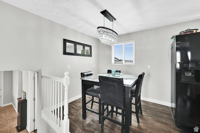 dining room with a textured ceiling, dark wood-style flooring, and baseboards