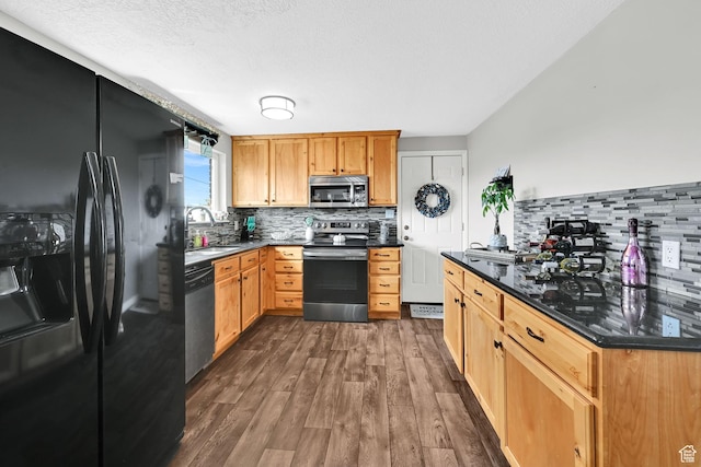 kitchen featuring a sink, decorative backsplash, dark wood-style flooring, and stainless steel appliances