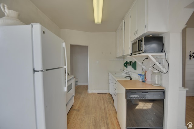 kitchen with light wood finished floors, light countertops, and white appliances