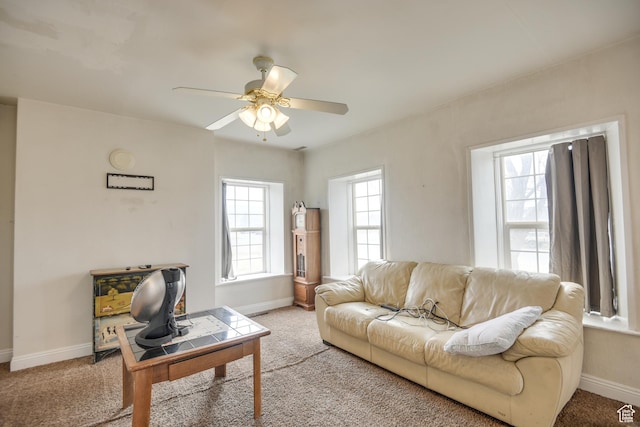 carpeted living room with baseboards and ceiling fan