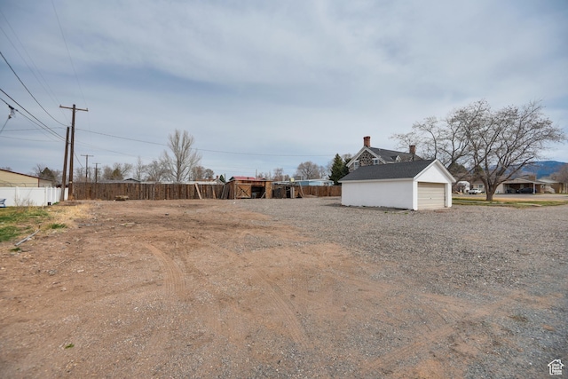 view of yard with an outbuilding, fence, and a garage