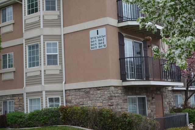 1617 W Treille Ct Unit I-5, West Valley City, UT 84119 - view of side of property with stucco siding, stone siding, and a balcony