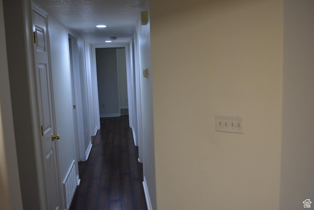 1617 W Treille Ct Unit I-5, West Valley City, UT 84119 - corridor featuring baseboards, visible vents, a textured ceiling, and dark wood finished floors