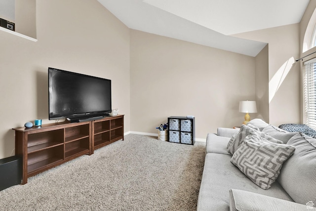 carpeted living area with baseboards and lofted ceiling